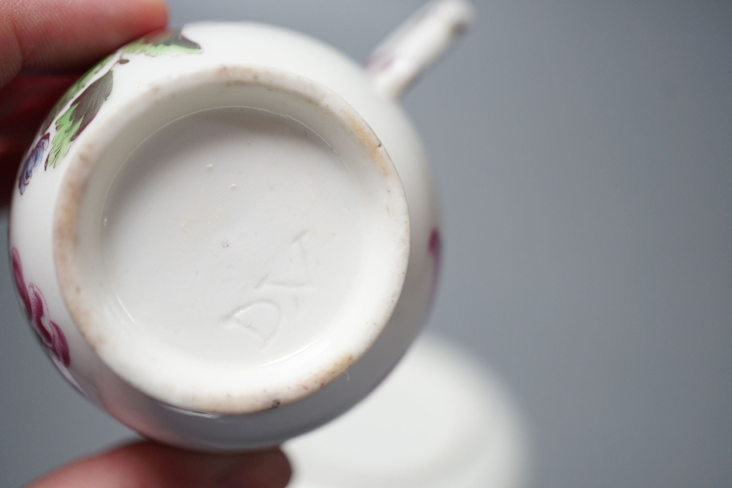 A Mennecy coffee cup and saucer painted with bold flowers, incised 'DV' mark c. 1755